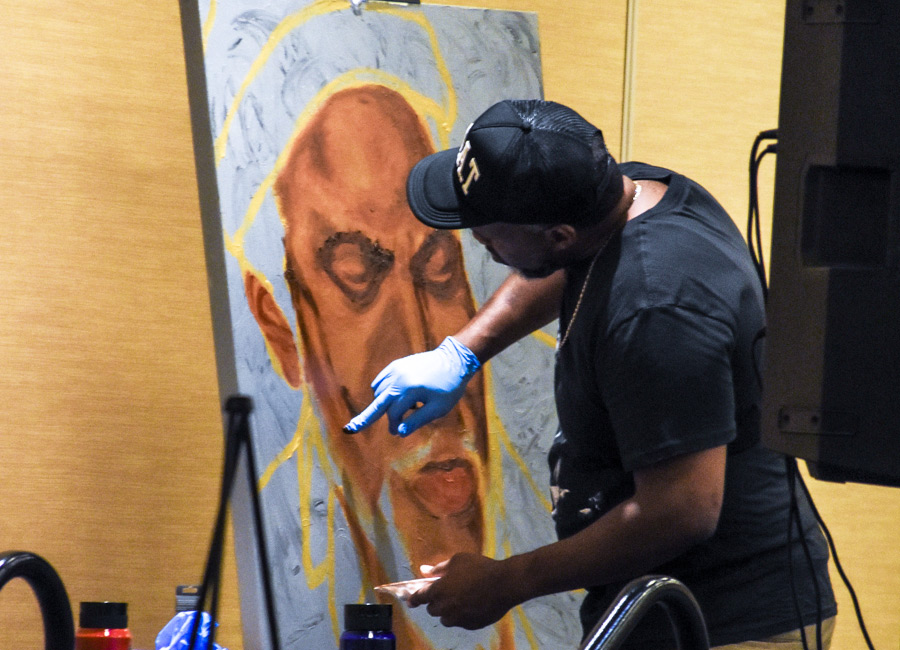 man finger painting at cultural arts pavilion event